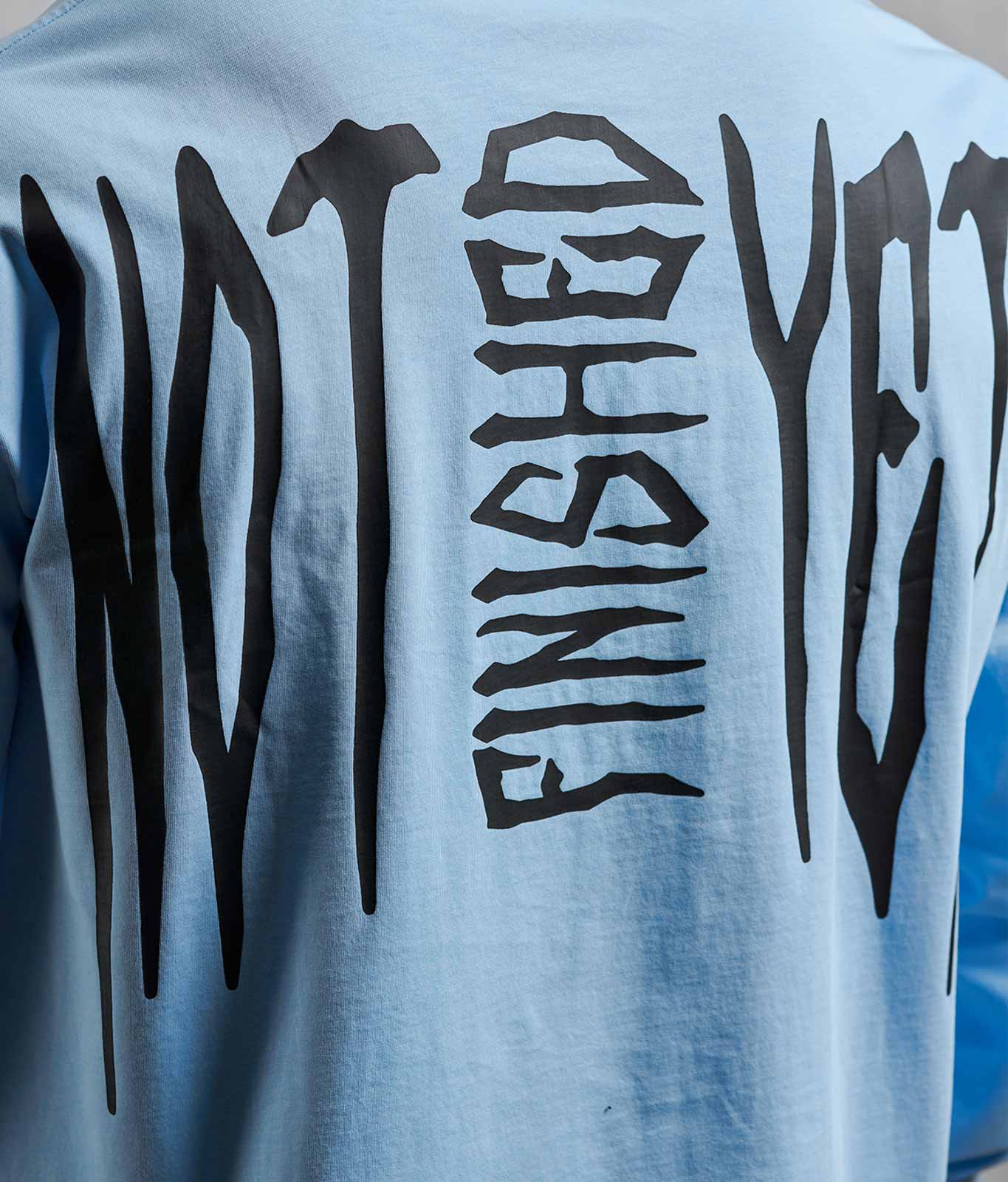 Nahaufnahme Not Finished Yet Backprint auf NOFY Longsleeve Blau After Dark